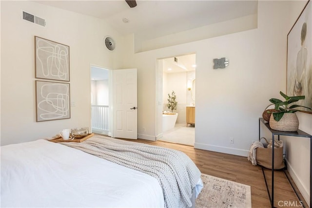 bedroom featuring connected bathroom, ceiling fan, hardwood / wood-style floors, and lofted ceiling