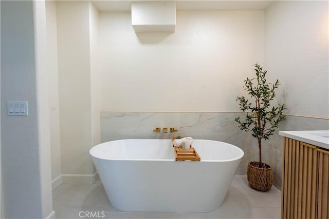 bathroom featuring tile patterned floors, vanity, a bath, and tile walls