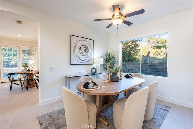 dining area featuring ceiling fan, plenty of natural light, light tile patterned floors, and crown molding