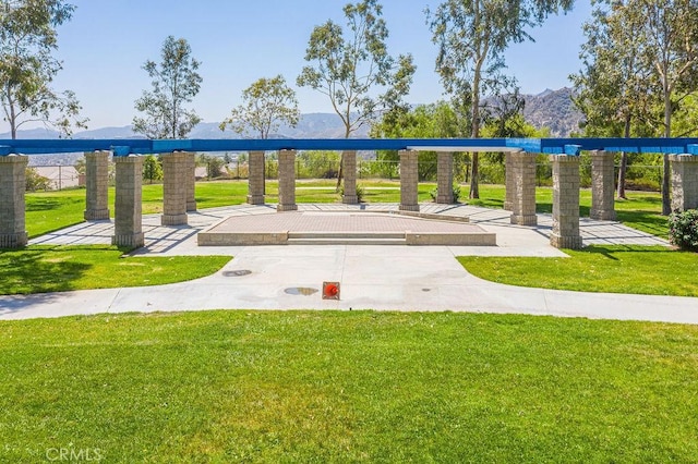 surrounding community with a lawn and a mountain view