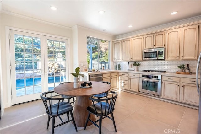 kitchen featuring light brown cabinetry, sink, stainless steel appliances, and light tile patterned flooring