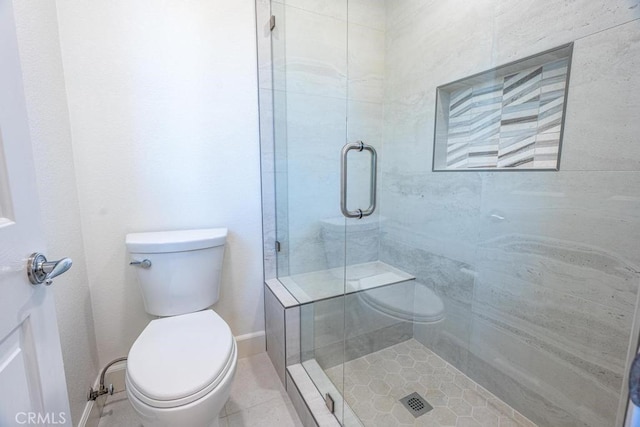 bathroom with tile patterned flooring, toilet, and a shower with door