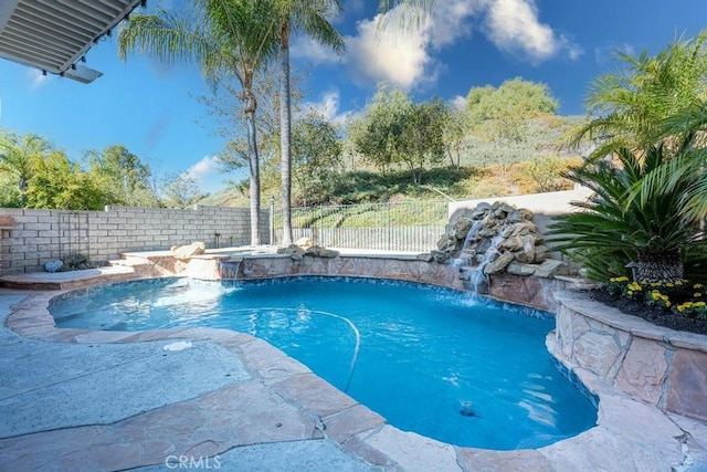 view of swimming pool featuring pool water feature and a hot tub