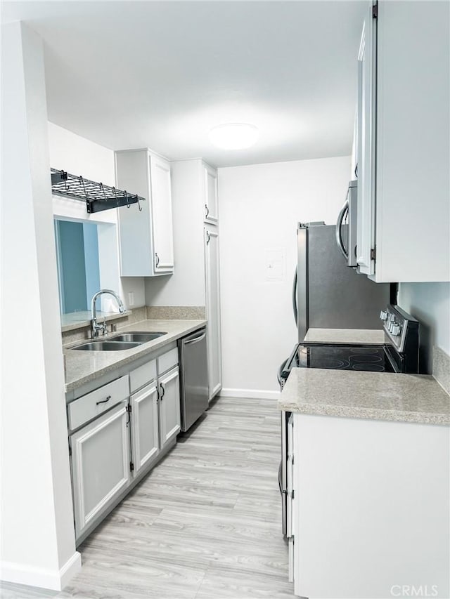 kitchen featuring light hardwood / wood-style floors, sink, white cabinetry, and stainless steel appliances