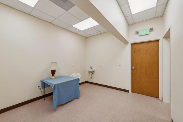 interior space with light carpet and a paneled ceiling