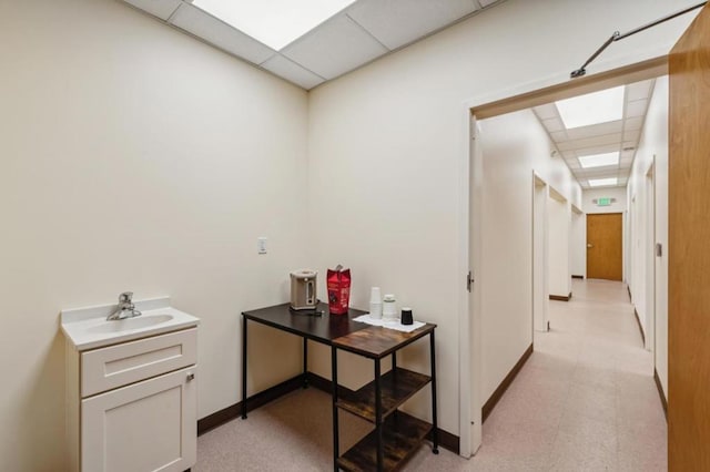 corridor with a drop ceiling and sink