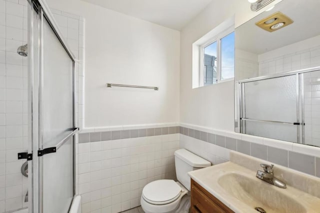 bathroom with a shower with door, tile walls, toilet, and vanity