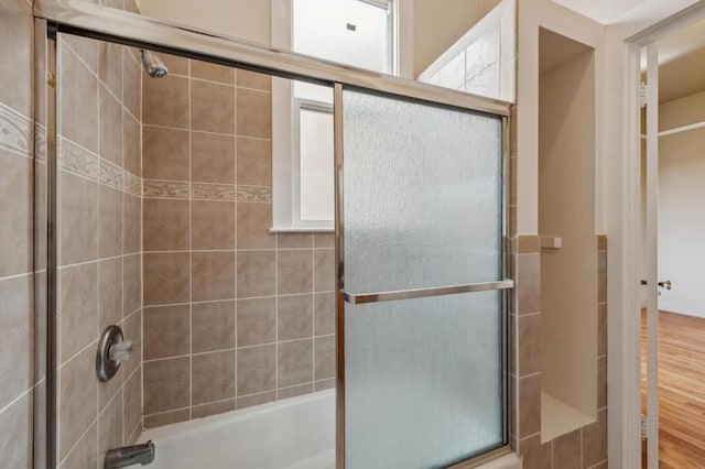 bathroom with bath / shower combo with glass door