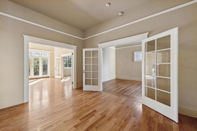 empty room with light wood-type flooring and french doors