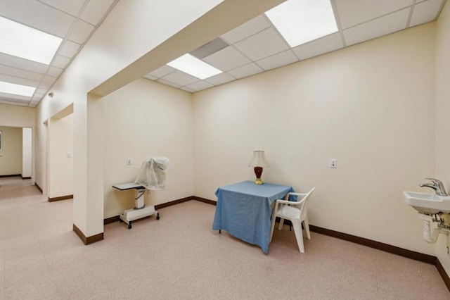 interior space with a paneled ceiling and sink