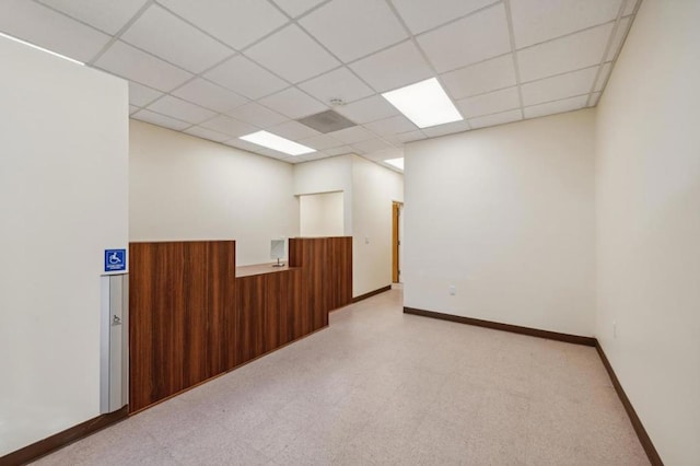 unfurnished room featuring a drop ceiling