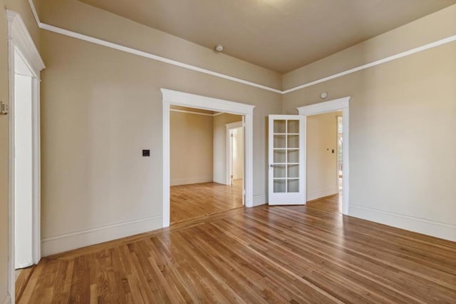 spare room featuring french doors and hardwood / wood-style flooring