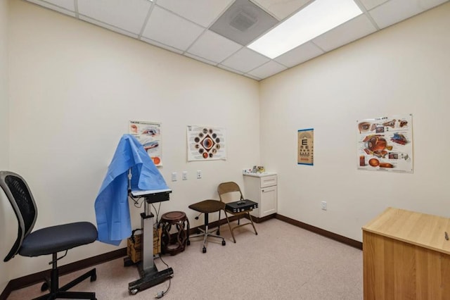 carpeted home office with a paneled ceiling