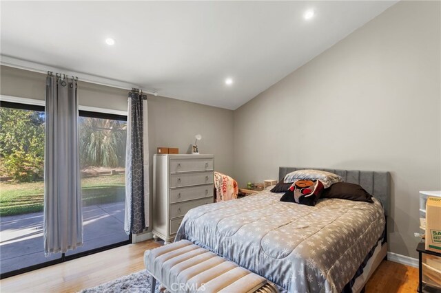 bedroom with access to outside, light hardwood / wood-style flooring, and vaulted ceiling