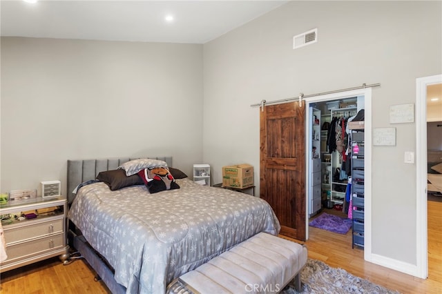bedroom with visible vents, a closet, a spacious closet, recessed lighting, and light wood-style flooring