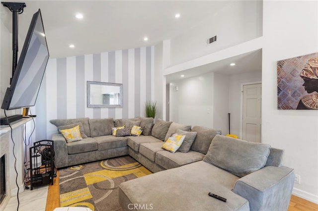 living room featuring baseboards, wallpapered walls, recessed lighting, and visible vents