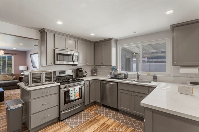 kitchen featuring stainless steel appliances, gray cabinets, and sink