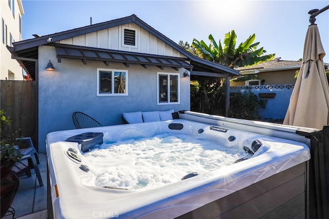 back of property with a hot tub