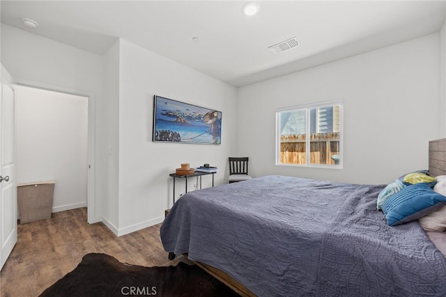 bedroom with dark hardwood / wood-style flooring