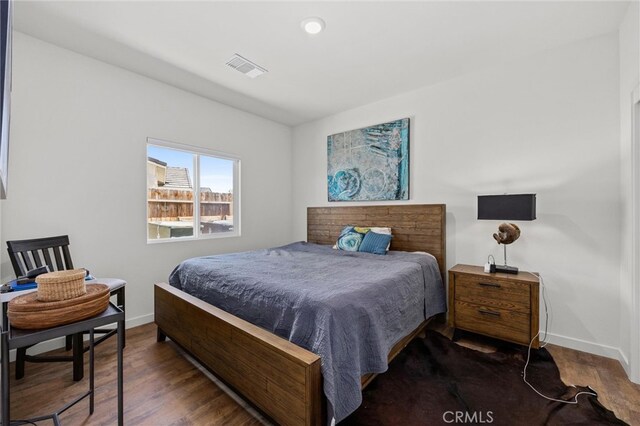 bedroom with dark hardwood / wood-style flooring