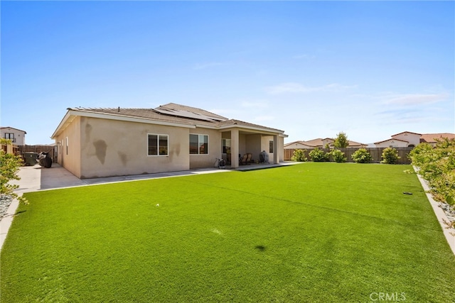 rear view of property featuring a patio area and a lawn