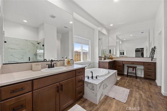 bathroom with vanity, wood-type flooring, and separate shower and tub