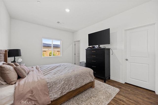 bedroom with dark hardwood / wood-style flooring