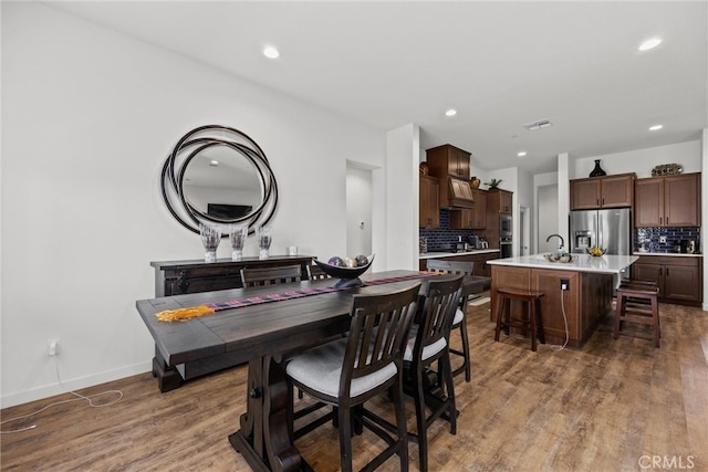 dining area featuring dark wood-type flooring and sink