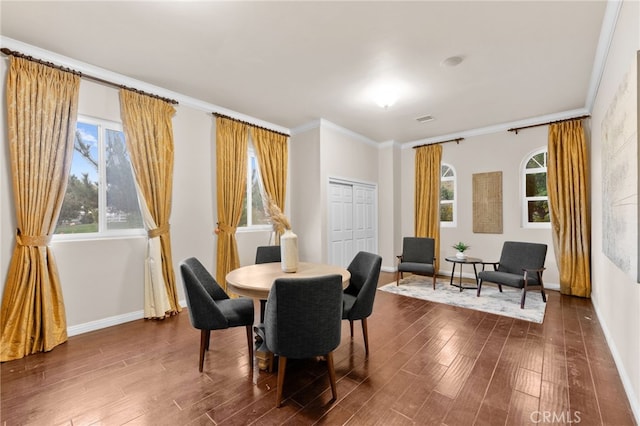 dining room with ornamental molding, a wealth of natural light, and dark wood-type flooring