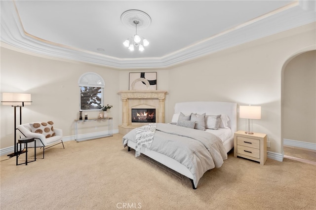 bedroom featuring a chandelier, carpet floors, ornamental molding, and a tray ceiling