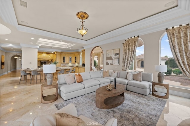 living room featuring a raised ceiling and ornamental molding