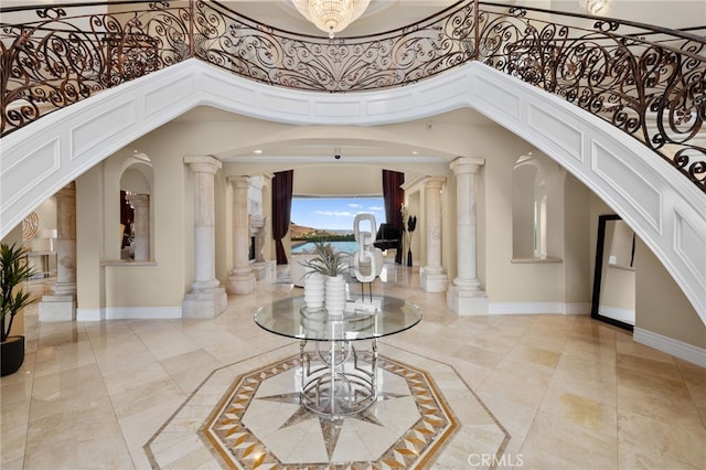 entrance foyer featuring a towering ceiling and decorative columns