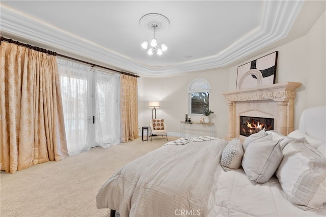 carpeted bedroom with a chandelier, ornamental molding, and a tray ceiling