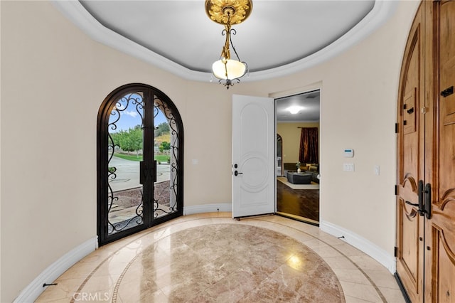 entryway featuring a tray ceiling and french doors