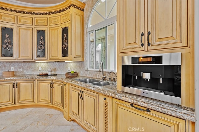 kitchen featuring light stone countertops, sink, and light brown cabinetry