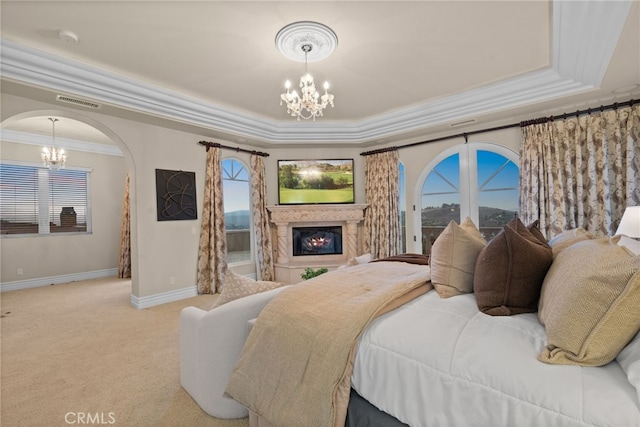 carpeted bedroom with a tray ceiling, access to exterior, crown molding, and an inviting chandelier