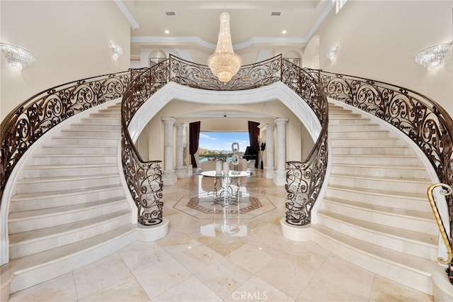 entryway featuring ornate columns, a chandelier, and ornamental molding