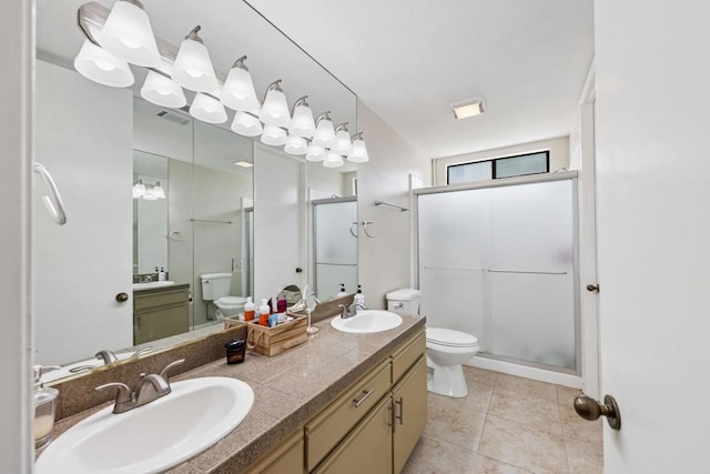 bathroom with tile patterned flooring, vanity, toilet, and walk in shower