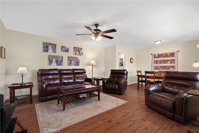 living room with dark hardwood / wood-style flooring and ceiling fan