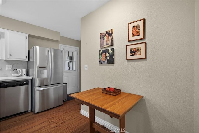 kitchen with white cabinetry, dark hardwood / wood-style floors, and appliances with stainless steel finishes