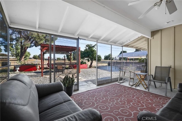 sunroom with vaulted ceiling with beams, ceiling fan, and a healthy amount of sunlight