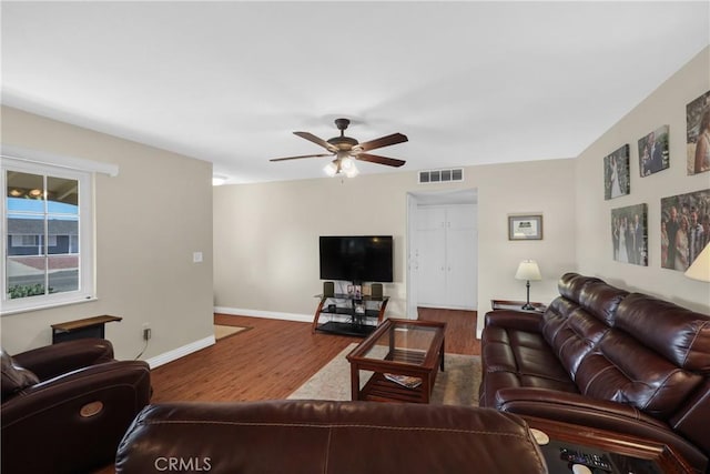 living room with wood-type flooring and ceiling fan