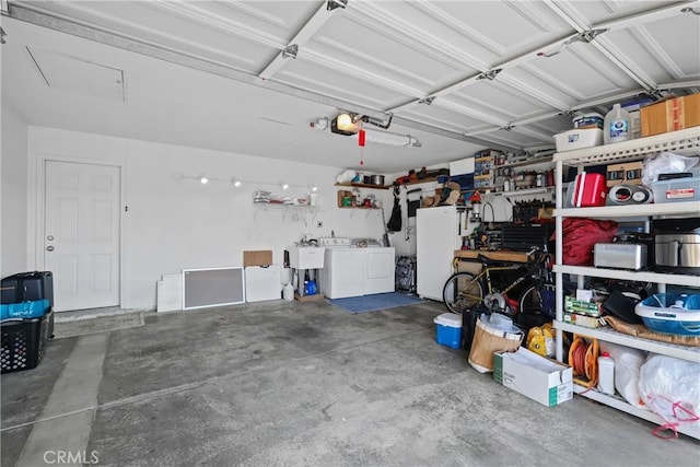 garage featuring sink, washer and dryer, and white refrigerator