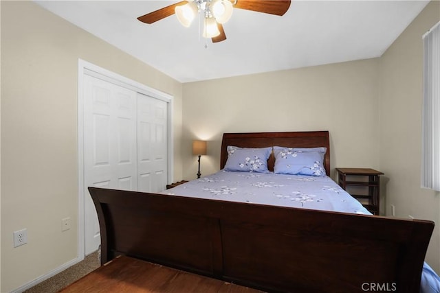 bedroom featuring dark colored carpet, ceiling fan, and a closet