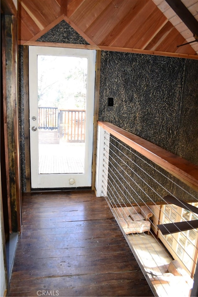 doorway to outside with vaulted ceiling with beams, dark hardwood / wood-style floors, wooden ceiling, and a wealth of natural light