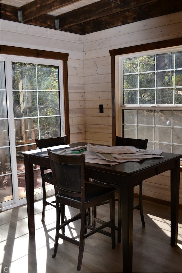 dining room with wood-type flooring and wood walls