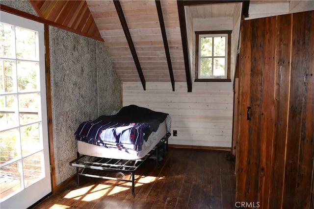 bedroom with lofted ceiling with beams, multiple windows, and wood walls