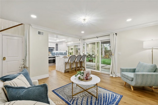 living room featuring light hardwood / wood-style flooring and ornamental molding