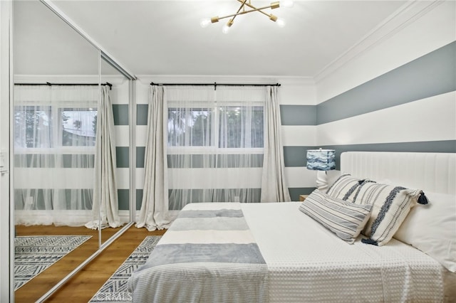 bedroom with ornamental molding, an inviting chandelier, and dark wood-type flooring