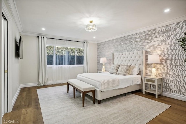 bedroom with hardwood / wood-style flooring, crown molding, and an inviting chandelier